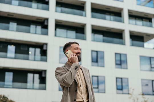 Smiling businessman talking on phone in urban setting