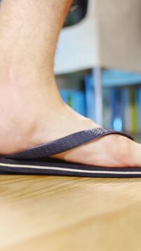 Flat feet in flip-flops walking over the frame in slow motion 