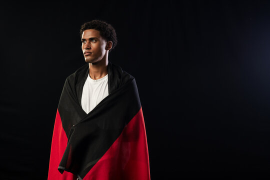 African American man standing and facing left, wearing red dark wrap over white T-shirt, copy space