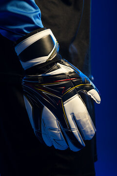 Middle-aged male wearing goalkeeper glove and blue jersey sleeve, showing wrist strap in studio