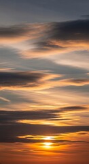 Fototapeta premium Fiery sunset streaks across a cloudy sky, painting the horizon with warm hues