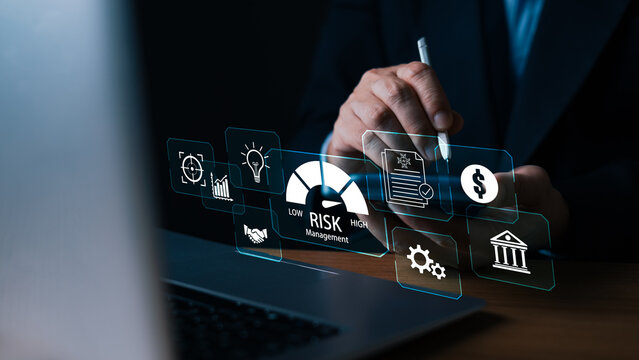 Businessman using a stylus on a digital tablet with a virtual risk management dashboard, analyzing financial data, assessment icons, and business security in a dark office setting.
