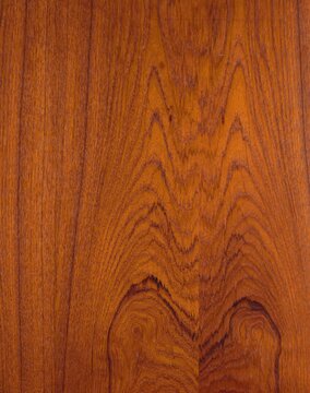 Oiled teak wood texture with rich red brown natural grain pattern.