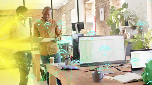 Vertical video: Team reading doc and pointing syncing IT plan as teal WiFi icons drifting over team