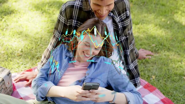 Couple reclining, woman tapping phone and making finance charts animate over torsos tracking stocks