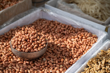 Obraz premium Roasted peanuts in a traditional Korean market stall with a metal scoop in South Korea