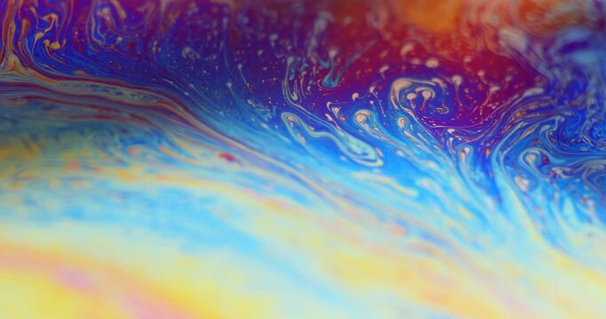 Spherical abstraction of iridescent blue, yellow and red colors with soft focus. Rainbow multilayer film. Natural environment.