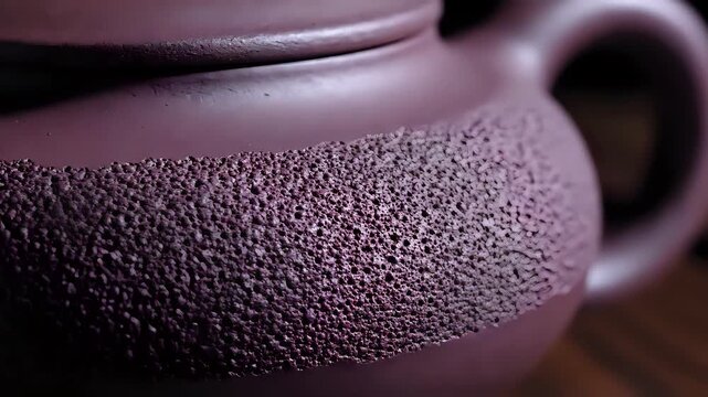 Closeup of a Textured Purple Teapot on a Wooden Surface.