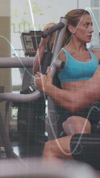 Vertical video: Woman gripping pec and training, trainer spotting, grid or wave overlaying duo in gy