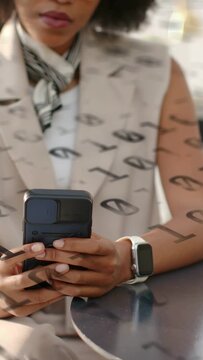 Vertical video: Seated businesswoman tapping phone and reading while etched glass overlay shifting