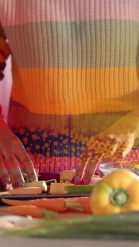 Vertical video: Cook reaching tray arranging veg rows counter dots overlay passing hands for prep