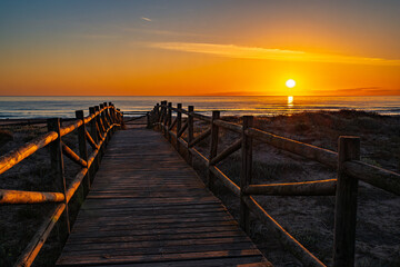 Obraz premium amanecer-playa-pasarela-madera.jpg.
