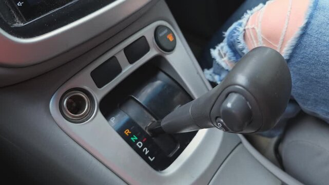 Shifting gears at a car's gear stick while parked and ready to drive