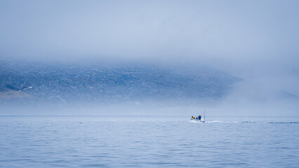 Boat sailing Disko Bay Greenland misty arctic waters © nicoescobarphoto