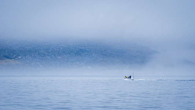 Boat sailing Disko Bay Greenland misty arctic waters
