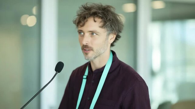 Man smiling at microphone in modern conference meeting room
