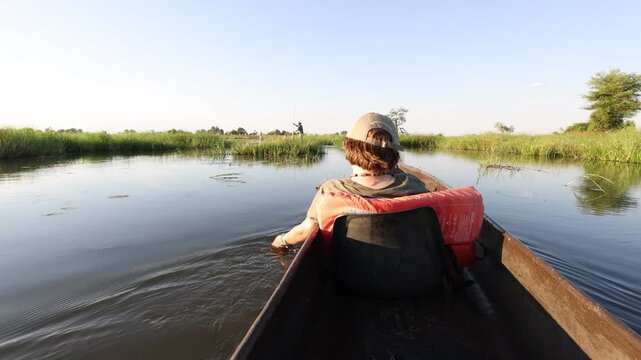 child's hand touching delta water, Okavango Delta, Botswana, Africa