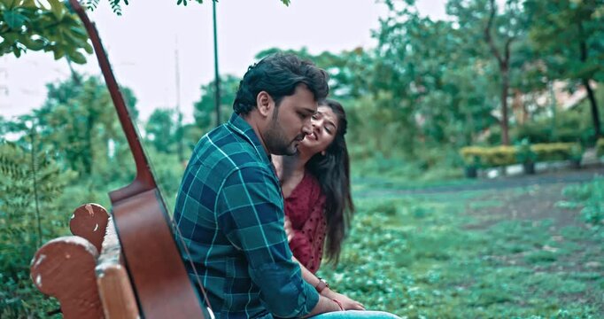 An emotional romantic scene where a man waits patiently for his girlfriend with a guitar, and after she arrives late, she lovingly apologizes and wins him back with affection