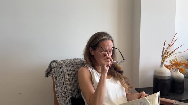 Mujer con primeros signos de presbicia por la menopausia leyendo un libro