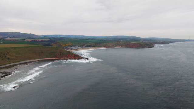 Aerial view of the dramatic promontory and rocky coves at Siccar Point coastline in Berwickshire Scotland