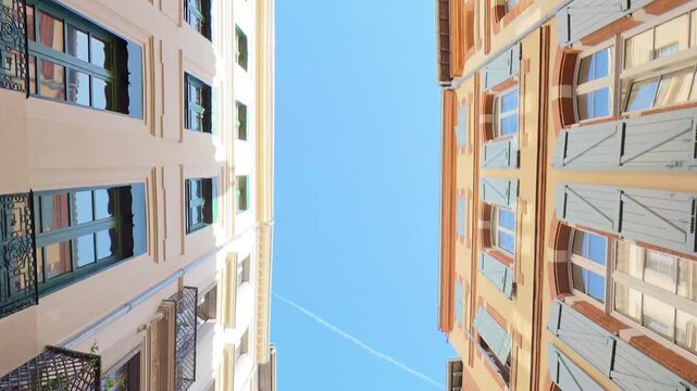 look up of  Historic building facades with shutters and balconies under blue sky