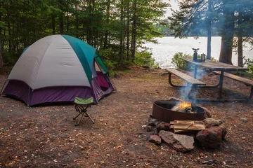 Campsite with tent fire picnic table and gear by a lake in a northern Minnesota state forest at dusk © Daniel Thornberg