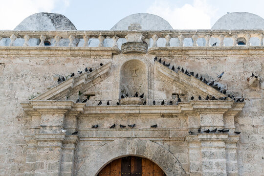 Cuba, Havana.  Pigeons perch on the tympanum above the main entrance to the Cathedral of St Francis of Assisi (Basilica of San Francisco de As&iacute;s) in old Havana