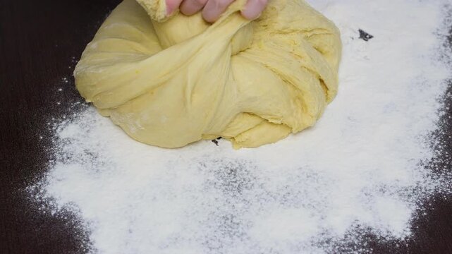 Woman hands stretching dough on floured wooden table pizza dough preparation closeup baking