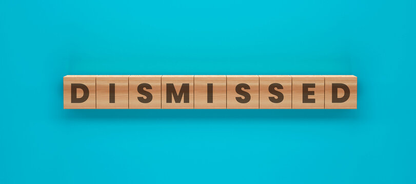 Dismissed: A minimalist composition of wooden blocks spelling out the word Dismissed against a vibrant aqua backdrop, a visual statement conveying finality or rejection.