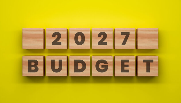 2027 Budget Concept: A conceptual depiction of the 2027 budget, presented on wooden blocks against a vibrant yellow backdrop, emphasizing financial planning and fiscal strategy.