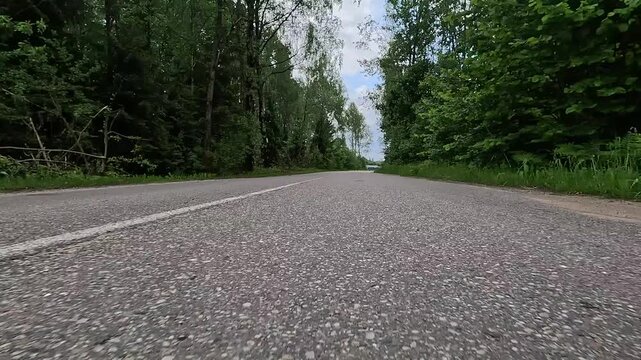 Video shooting in motion, driving a red car over the road along the asphalt at speed, view from the wheel.