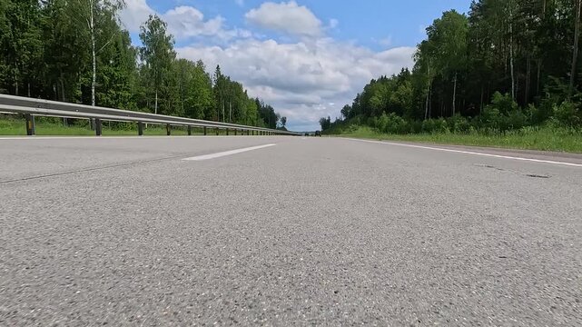 Video shooting in motion, driving a red car over the road along the asphalt at speed, view from the wheel.