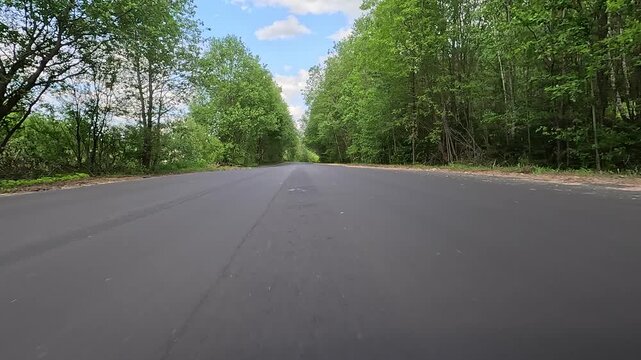 Video shooting in motion, driving a red car over the road along the asphalt at speed, view from the wheel.