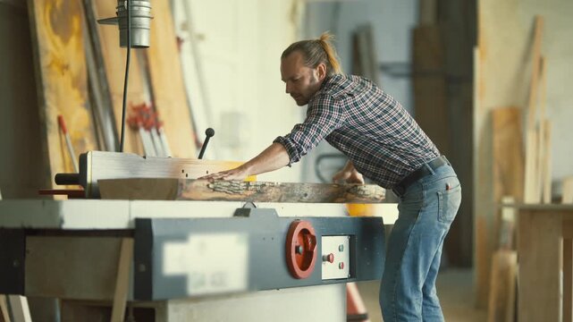Professional carpenter working on a planing machine