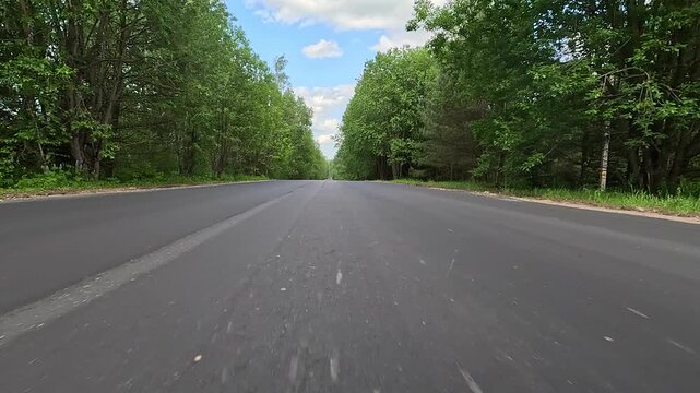 Video shooting in motion, driving a red car over the road along the asphalt at speed, view from the wheel.