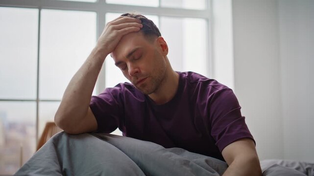Hangover man feeling headache having cough suffering at wakeup on bed closeup