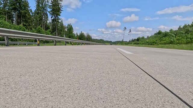 Video shooting in motion, driving a red car over the road along the asphalt at speed, view from the wheel.