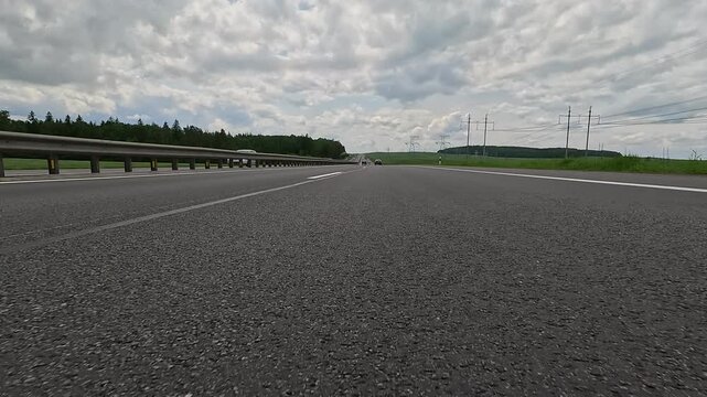 Video shooting in motion, driving a red car over the road along the asphalt at speed, view from the wheel.