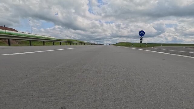 Video shooting in motion, driving a red car over the road along the asphalt at speed, view from the wheel.