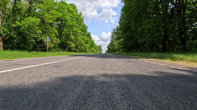 Video shooting in motion, driving a red car over the road along the asphalt at speed, view from the wheel.