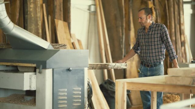Carpenter using a thickness planer machine