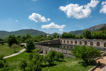 Fototapeta premium The historic pond at the gardens of the Royal Monastery of San Lorenzo de El Escorial, a UNESCO World Heritage site near Madrid, Spain, under a beautiful sunny sky.