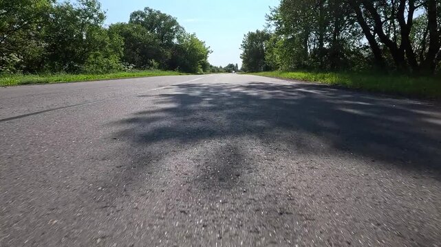 Video shooting in motion, driving a red car over the road along the asphalt at speed, view from the wheel.