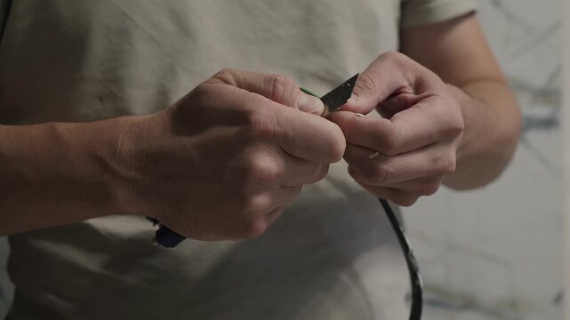 Electrical repair process. Homeowner fixing frayed cord carefully. Closeup of electrical repair and safety procedures. Detailed scene of person restoring worn electrical wire with safety precautions