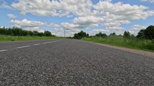 Video shooting in motion, driving a red car over the road along the asphalt at speed, view from the wheel.