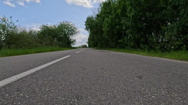 Video shooting in motion, driving a red car over the road along the asphalt at speed, view from the wheel.
