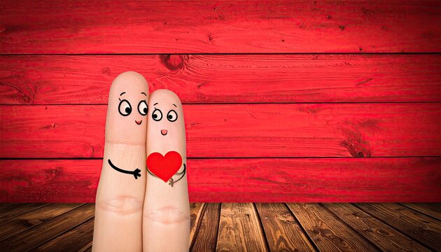 Finger puppets couple with a red heart against a vibrant red backdrop
