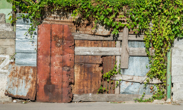Cuba, Cienfuegos.  Multiple repairs to a building's exterior wall using various found materials.
