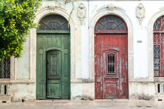 Cuba, Cienfuegos.  Red and green entrance doors to homes on the main street.