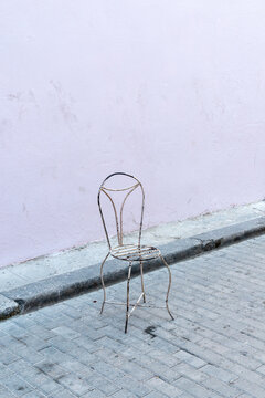 Cuba, Havana.  A lone metal chair on the side of the road in old Havana.